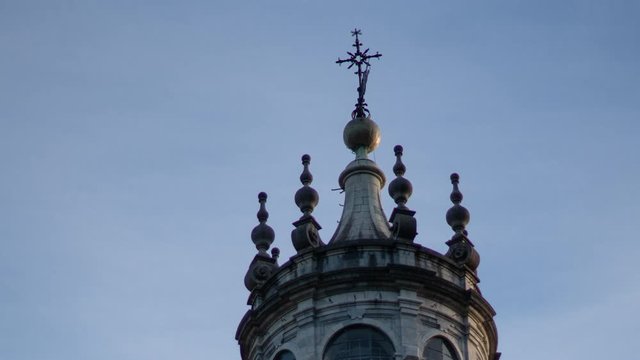 Clouds sweet by the cross on top of the Santuario de Loiola basilica in Spain. Cinematic time lapse.