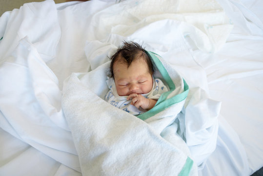 Bebé recién nacido en cuna de hospital