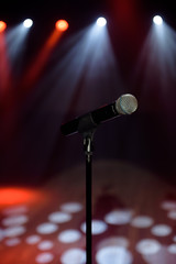 Obraz premium Close-up of microphone at concert against blur colorful light background