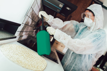 Specialists in protective suits do disinfection or pest control in the apartment. - obrazy, fototapety, plakaty
