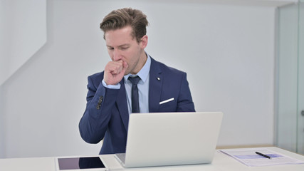 Sick Young Businessman Working on Laptop and Coughing