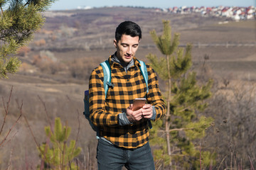spring outdoors. handsome man in countryside using phone to navigate