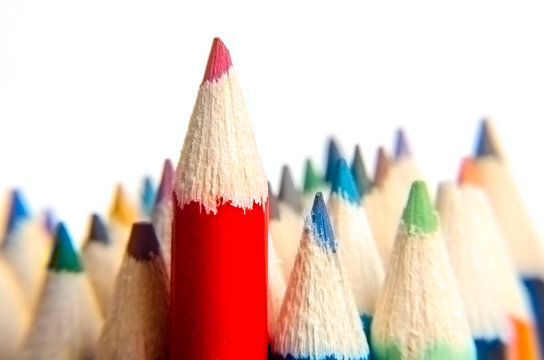 Red pencil close up. Red color pencil stand on various color pencils on white background, blur image. Leadership concept. Back to School. Color pencils isolated on white background. selective focus.