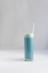 Blue matcha latte or butterfly pea flower latte in a tall glass cup