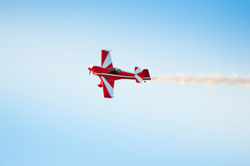 Acrobatic airplane in the sky with smoke signal