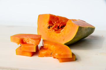 Sliced papaya on a white cutting board