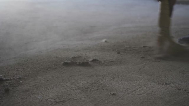 Worker sweeping a dusty concrete floor
