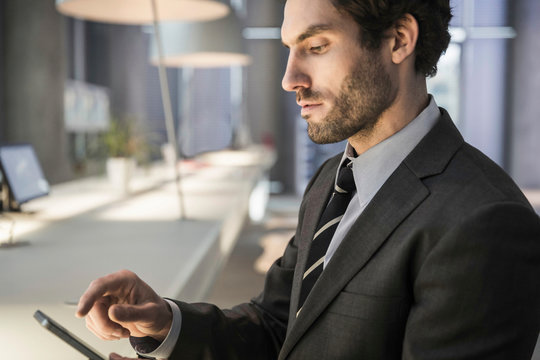 Businessmann am Handy an Theke