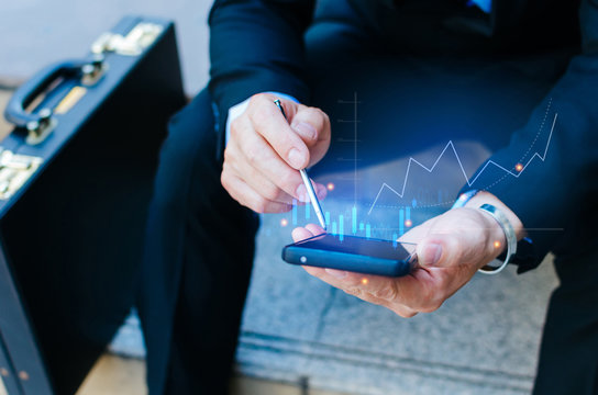 investor or business man with briefcase using stylus pen on mobile phone with visual graphic graph chart of stock market investment trading for Forex trading, investment, digital technology concept