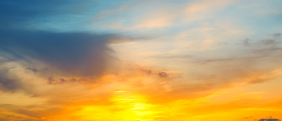 Fototapeta premium Cloudy sky and bright sunrise over the horizon. Wide photo.