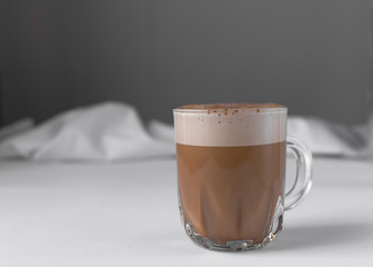 Coffee with milk and foam in a glass coffee cup