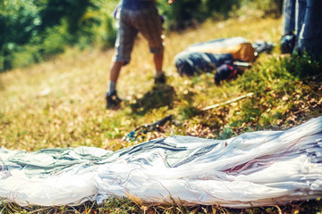 Paragliding in the mountains, paraglider on the ground.