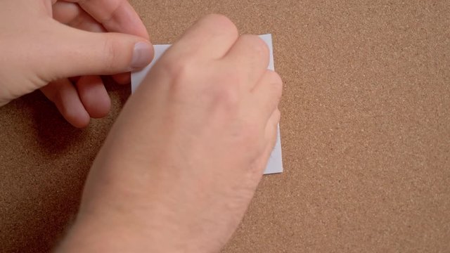 Human hands attach a sticker to the blackboard with the word WEEKEND