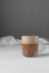 Coffee with milk and foam in a glass coffee cup