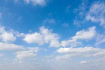 Fluffy white clouds on blue sky background.