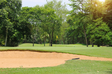 The evening golf course has sunlight shining down at golf course in Thailand