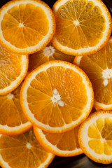 juicy oranges cut round on a dark background close up