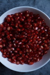 pomegranate berries are red close-up on a dark blue background. cut garnet with blurred background