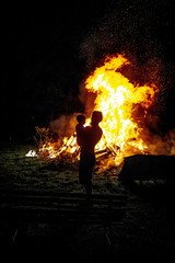 father holding his little son with burning bonfire on background, fatherhood and joy of life. Light graphic effect.