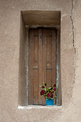 flowerpot on Niche and wooden window in a wall