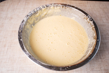 Dough for crepes or pancakes in glass bowl top view