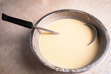 Fototapeta na wymiar Dough for crepes or pancakes in glass bowl top view