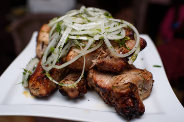Delicious freshly cooked barbecue on a large white plate. Tasty meat. Close-up.