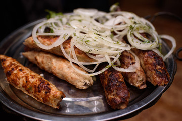 Delicious freshly cooked barbecue on a large white plate. Tasty meat. Close-up.