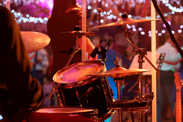 Drummer plays the drums during party event or wedding celebration and dancing couples in the background