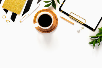 Flat lay desk table. Workspace with modern gold and black clipboard, stationery and a cup of coffee on white table. Copy space, top view