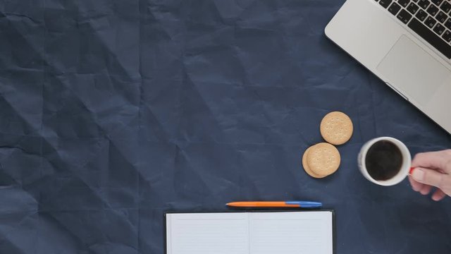 laptop, notebook, pen, coffee and cookies on a blue background, crumpled paper, copy-space