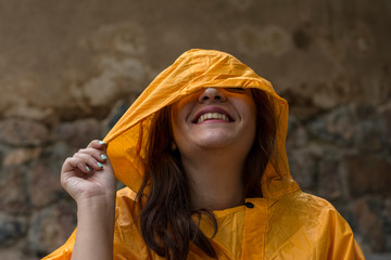 happy young girl in yellow rain coat