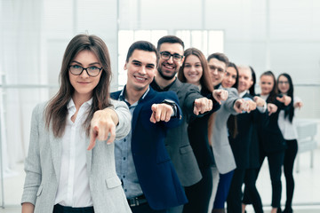 large group of young business people are pointing at you