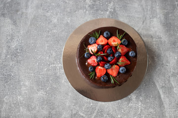 Chocolate birthday cake with strawberry and blueberry. Top view