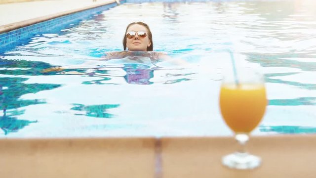 Woman relaxing in the swimming pool.