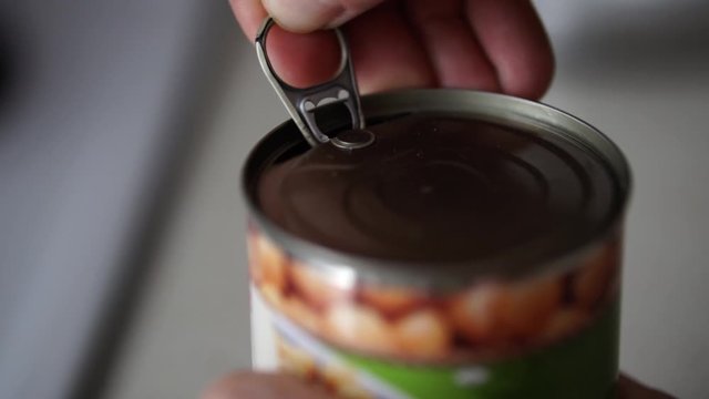 Hand of caucasian male opening tinned cooked chickpeas, SLOW MOTION