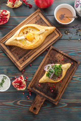 Traditional Georgian khachapuri bread with cheese and meat on wooden table