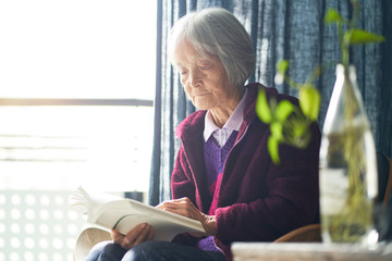 senior asian woman sitting & reading book enjoying retirments