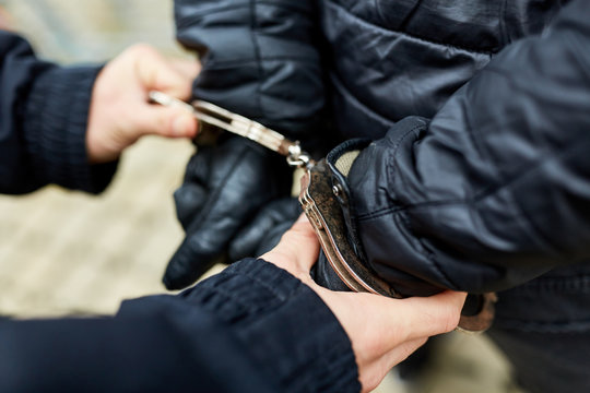 Polizist beim Abf&uuml;hren von T&auml;ter in Handschellen