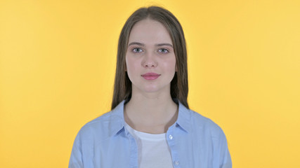 Casual Young Woman Looking at the Camera, Yellow Background