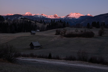 Sheds with sunlit mountains in background