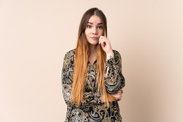 Young caucasian woman isolated on beige background thinking an idea