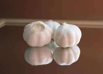 Garlic bulbs and garlic cloves on a mirror. Aromatic herb background.