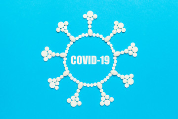 Virus concept made of pills on blue background. Epidemic of coronavirus (COVID-19), dangerous...