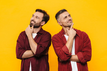 Image of two handsome men thinking and looking upwards at copyspace