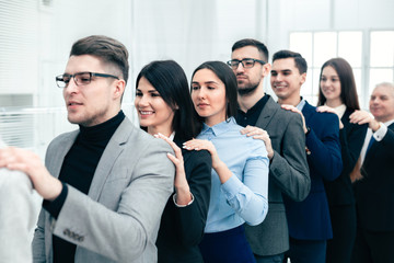 group of corporate employees standing behind each other.