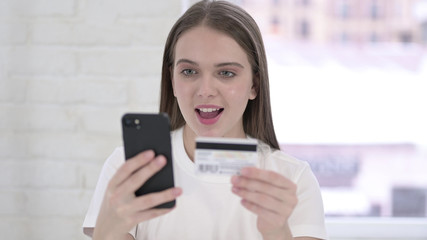 Portrait of Young Woman Celebrating Success on Smartphone