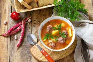 The concept of healthy and diet food, vegetarian dish. Delicious Vegetable soup with bean balls on a rustic table. Copy space.