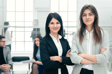 two young business woman standing in office