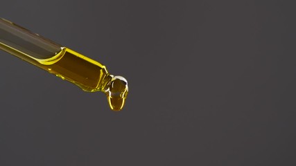 Close-up aromatheraphy oil drops dripping from dropper, anti aging serum skin care - Powered by Adobe